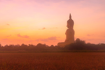 sunrise above the great Buddha of Thailand at wat Muang Ang Thong Thailand. .The largest Buddha statue in the world Can be seen from afar Surrounded by rice fields.