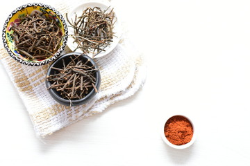 Saffron seasoning in root and powder, exhibited in containers on white wooden board