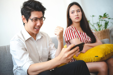 Women are angry at men playing a game phone. By ignoring her. Psychology, relationship problems and divorce concept.