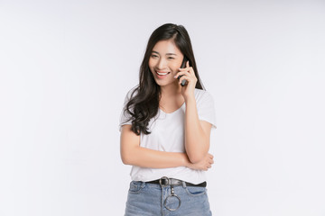 Happy Asian businesswoman using mobile phone isolated over white background. Girl holding the smartphone in a summer t-shirt Short jeans. Copy space