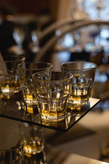 Close up of lot of glasses of fresh cognac or whiskey on bar table. Party and holiday celebration concept