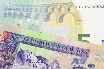 A colorful two dollar bill from Belize in close up macro with a blue and green five euro, European bank note