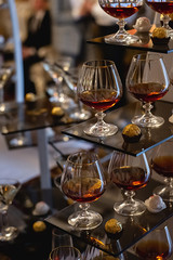 A lot of glasses of fresh cognac on bar table. Party and holiday celebration concept