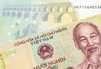 A colorful ten thousand dong note from Vietnam close up in macro with a blue and green, European five euro bank note