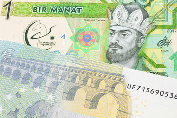 A green one manat note from Turkmenistan close up in macro with a five euro bank note from the European Union's central bank