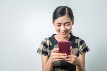 Young woman holding smartphone and chat with friends, studio shot, using mobile to checking new feed.