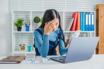 Stressed young asian woman administrative work holding bills after shopping online in special lower...