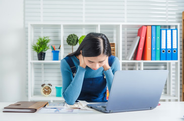 Stressed young asian woman administrative work holding bills after shopping online in special lower price day and discount coupon, she pay much money.