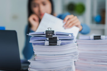 Young employee woman hands checking stack of paper files for searching unfinished document arheieve after finish busy hard working. - obrazy, fototapety, plakaty