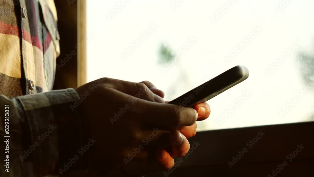Poster Man using smartphone in the room with window background. Use smartphone in the morning for social media or chat