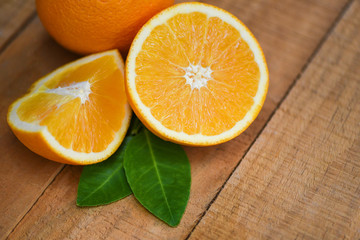 Fresh orange slice half and orange leaf healthy fruits harvest concept - Orange fruit on wooden background