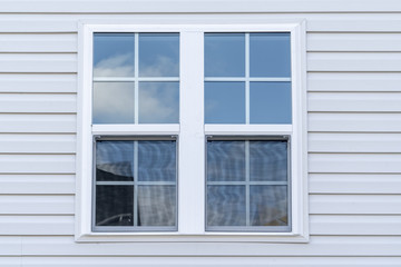 Double hung window with fixed top sash and bottom sash that slides up, sash divided by white...