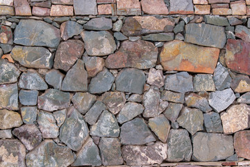 Stone wall for the backdrop. Sharp blocks of color with shades of gray and brown. Concept of old antique masonry.