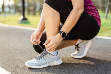 closeup of young woman runner tying her shoelaces. healthy and fitness concept.