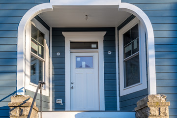 Interesting covered porch with inward windows Hardwood white front door in the entryway white frame...