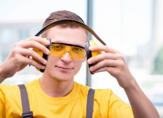 Young construction worker in yellow coveralls