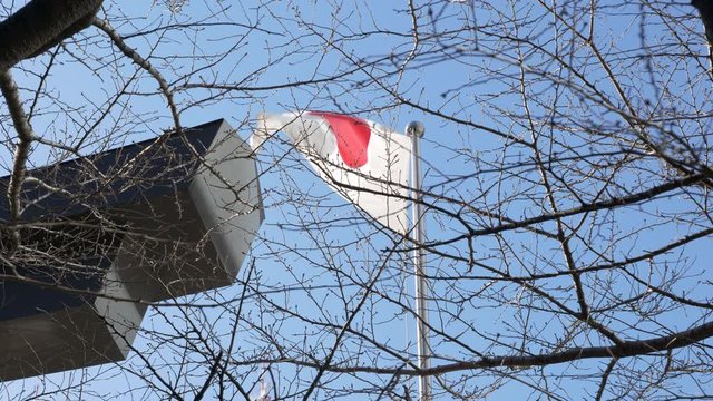 Japan national flag waving and fluttering against blue sky
