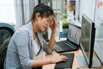 Stressed frustrated young asian businesswoman reading bad email internet news on computer feeling sad tired. confused female freelance worker upset about problem online during work in home office