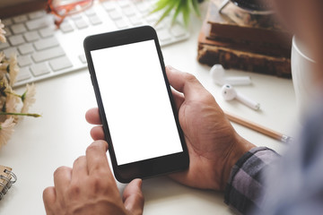 Cropped shot view of man hands holding smart phone with blank copy space screen for your text message or information content, female reading text message on cell telephone during in urban setting. 