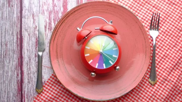 alarm clock on plate wooden background 