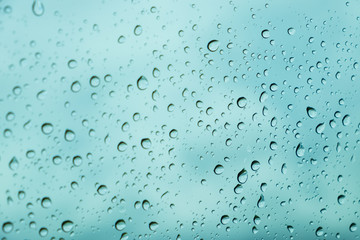 Drops of rain on blue glass background / drops on glass after rain