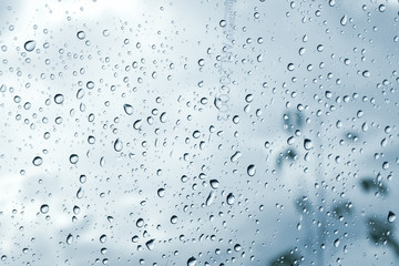 Drops of rain on blue glass background / drops on glass after rain