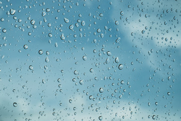 Drops of rain on blue glass background / drops on glass after rain