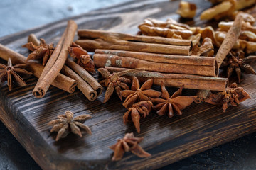 Cinnamon sticks, star anise and nuts on a wooden board