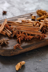 Cinnamon sticks, star anise and nuts on a wooden board