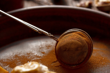 Cinnamon powder in a culinary strainer. Baking ingredient