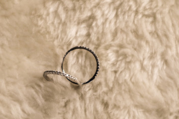 Couple rings placed on a soft wool rug. Ove all is  a sepia tone picture.