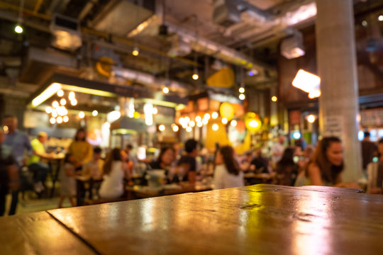 Empty real wood table top with light reflection on scene at restaurant, pub or bar at night.