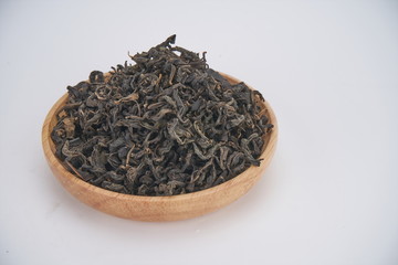 The dried green tea leaves are in the wooden tea tray