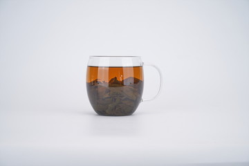 There is a cup of black tea in the transparent glass