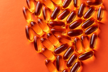 fish oil capsules on red background close-up