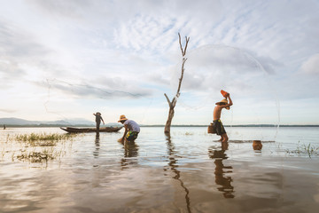 Blurry image of Children tease each other with fun. His uncle casting a net for catching freshwater...
