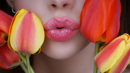 Fototapeta na wymiar 8 march women's day. Woman with tulips kiss. Kissing. Lips and flovers close up.