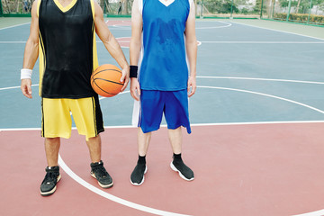 Sweaty young sportsmen tired after playing basketball on outdoor court