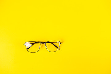 metal retro glasses on a yellow background