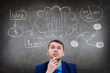 Young businessman looks up on different icons above head.