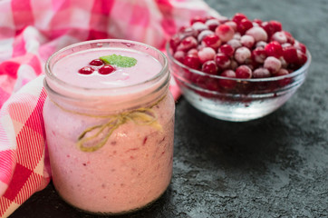 Natural yogurt with frozen cranberry berries. Close-up.