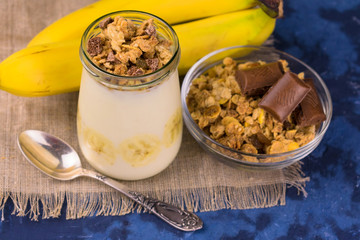  Natural yogurt with granola, chocolate and banana. Top view.