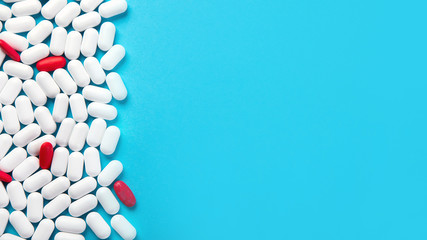 Obraz premium Sterta pigułek na niebieskim tle
