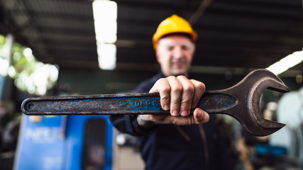 Selective focus of the Wrench held by an industrial worker in the factory atmosphere, concept of working tools, factory safety manufacturer, manufacturer  procedure, effective tools in the factory.