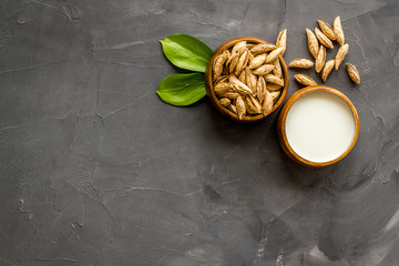 Alternative milk made from almond. Drink near unpeeled on grey stone table top-down copy space