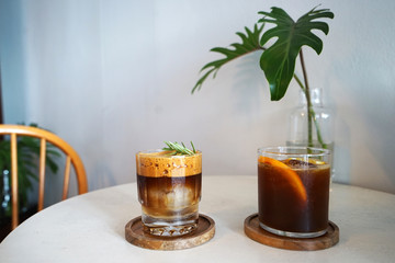 Glasses of iced black coffee on wooden tray
