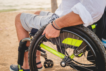 Disabled man in a wheelchair on the beach.