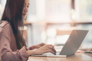 Young asian female working with computer laptop.