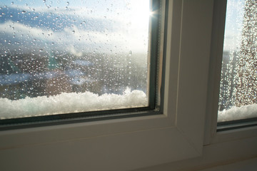 home window in the snow after a snowfall on the background of the shining sun. beautiful winter weather