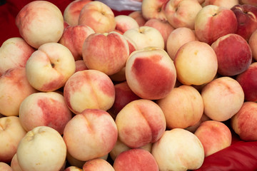 A pile of bright red peach collected from the tree Prepare to be released for sale to customers. That are healthy and eaten. fruit background.